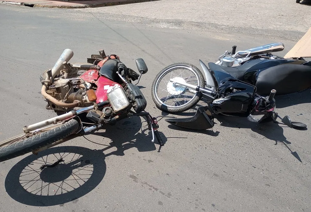 Duas motocicletas caídas no asfalto após acidente