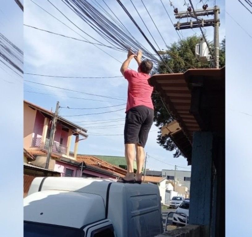 Lei contra fiação solta não é fiscalizada, e morador se arrisca para resolver problema em Cabreúva